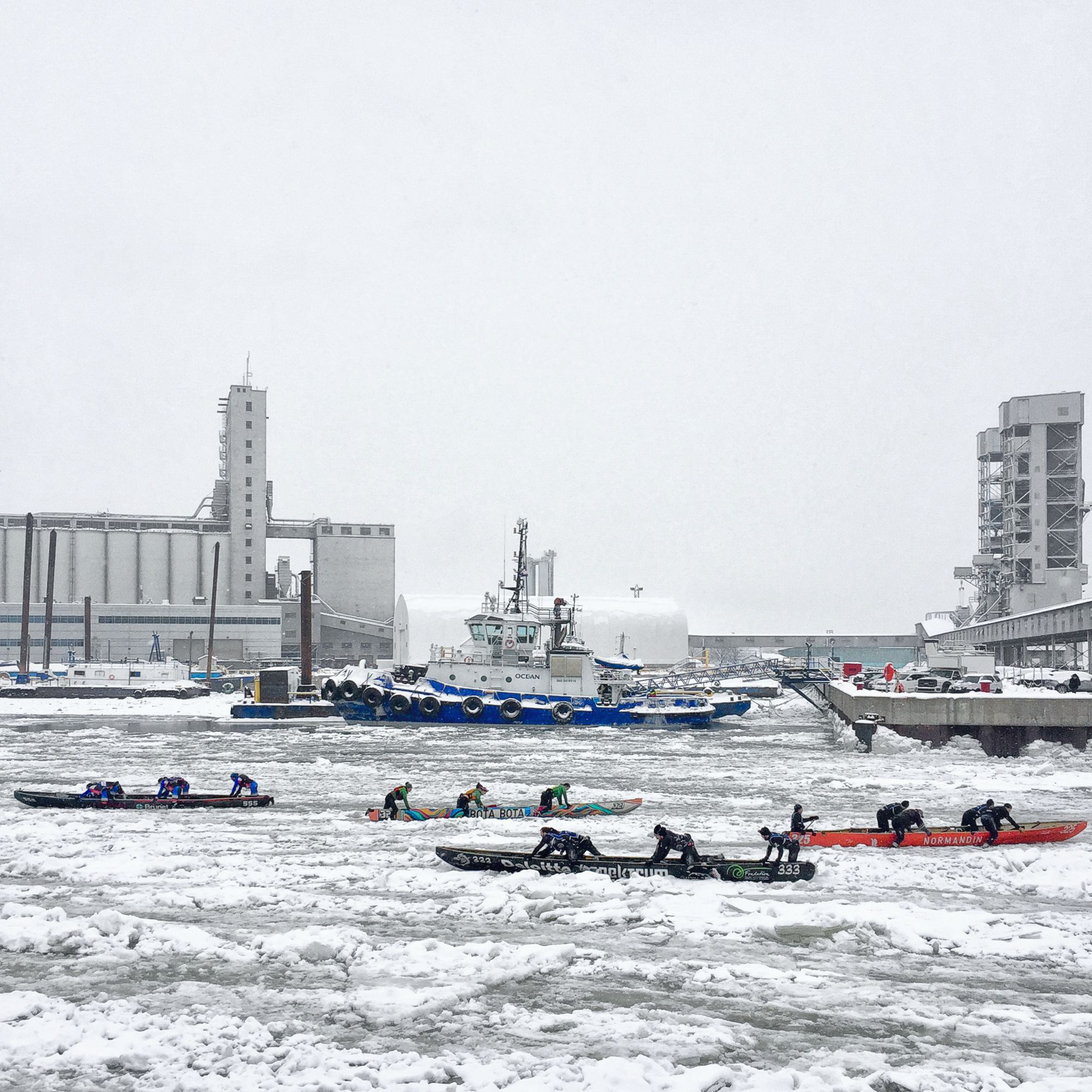 Quatre canots et équipage dans le Port de Québec pour la traversée hivernale du Fleuve Saint-Laurent.