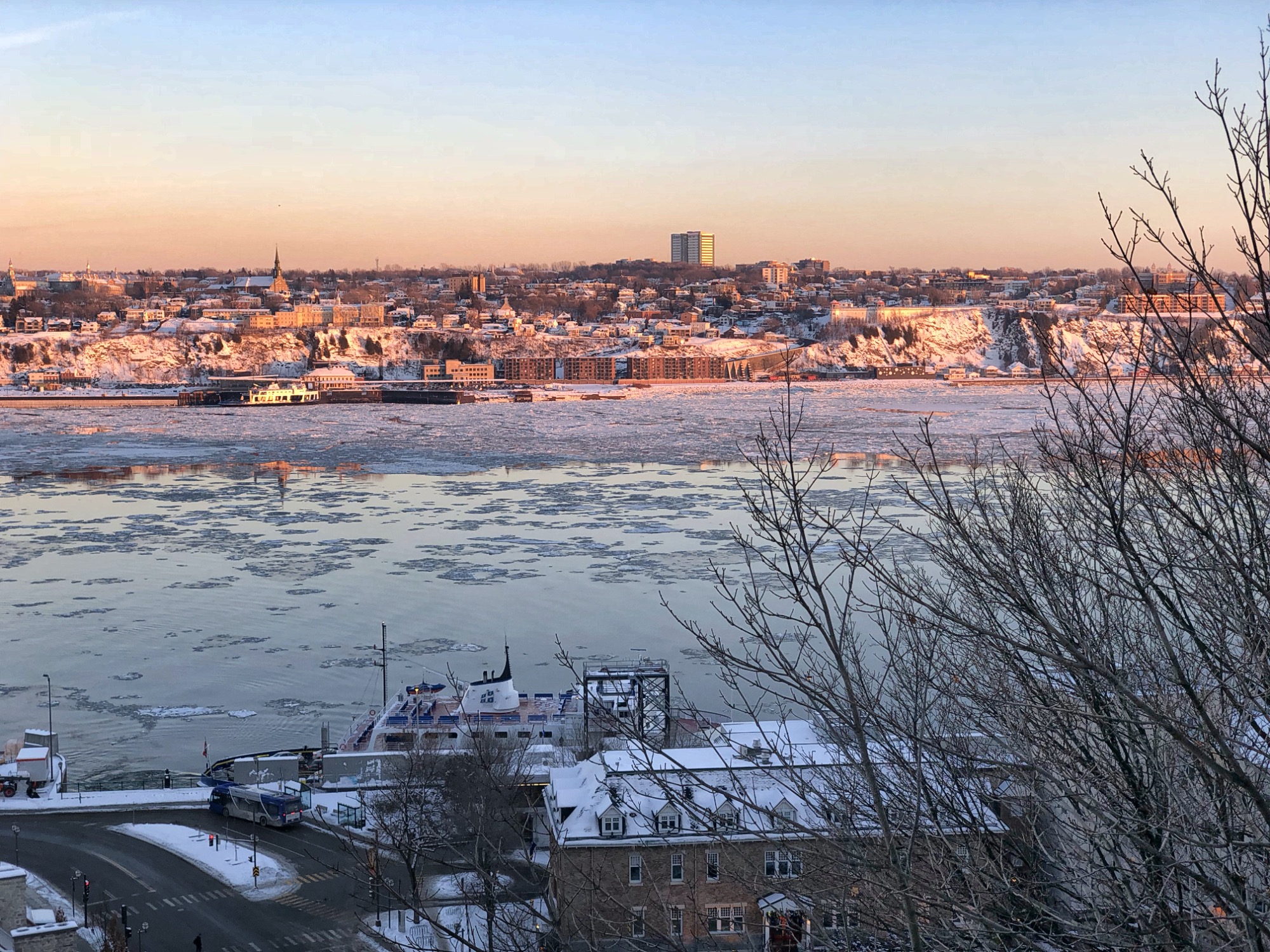 Winter view of golden sunset light over the icy water of the Saint-Lawrence river near Québec City